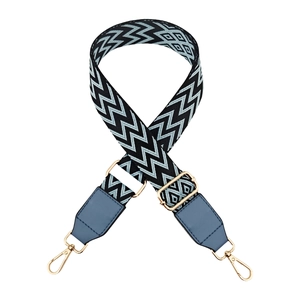 Detail of adjustable wave pattern canvas bag strap with golden metal lobster clasps