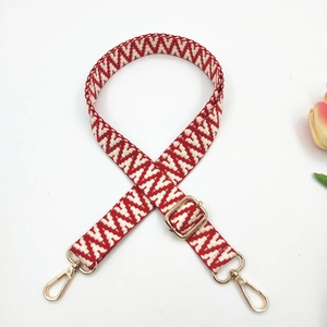 Detail of red and white geometric jacquard strap with adjustable golden metal hooks