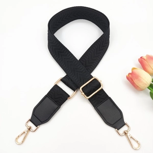 Close-up of adjustable wide woven bag strap with black PU leather and gold hooks
