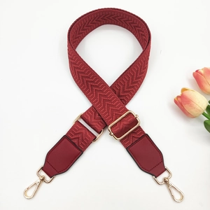 Close-up of burgundy chevron strap with gold swivel hooks and adjustable buckle