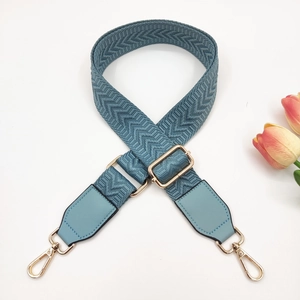 Macro shot of Morandi blue 3.8cm wide woven bag strap with golden hardware details