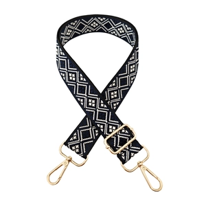 Close-up of navy blue geometric jacquard wide bag strap with gold metal lobster clasps
