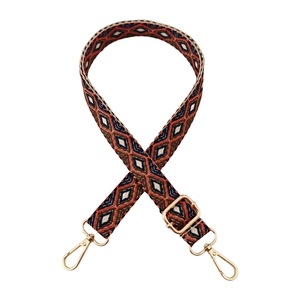 Detail of vintage geometric jacquard bag strap with golden metal swivel hooks