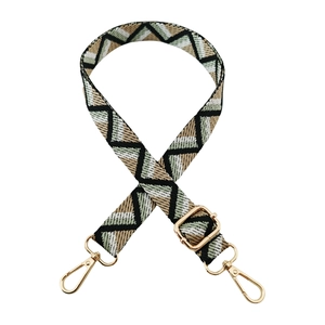 Detail of adjustable woven purse strap with colorful geometric pattern and gold hardware