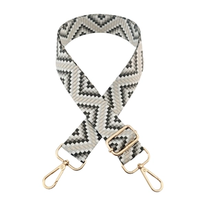 Close-up of geometric chevron pattern woven strap with gold metal hooks for bags