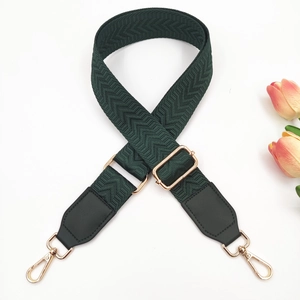 Detail of dark green chevron woven strap with polished light gold metal hardware clips