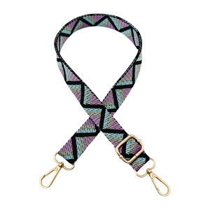 Detail of colorful geometric woven bag strap with adjustable buckle and gold hooks