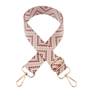 Detail of adjustable woven bag strap with pink geometric waves and gold metal hooks