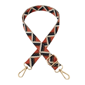Close-up of adjustable geometric jacquard bag strap with gold metal lobster clasps