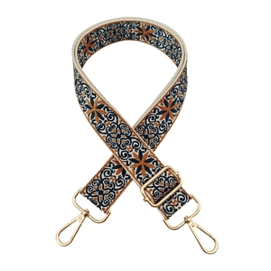Close-up of adjustable ethnic jacquard strap with floral patterns and gold metal buckles