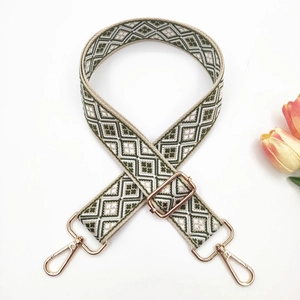 Detail view of ethnic geometric jacquard strap with gold lobster clasps and tulip
