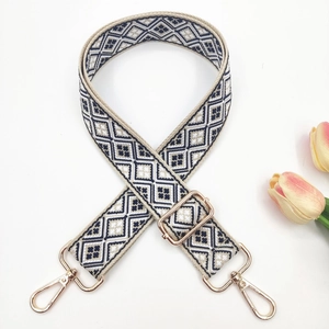 Detail of bohemian geometric navy and white woven wide strap with gold metal hooks