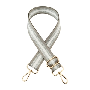 Close-up of adjustable striped bag strap with metallic thread and gold lobster clasps