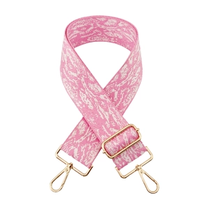 Detail of thickened pink and white woven bag strap with adjustable gold metal hardware