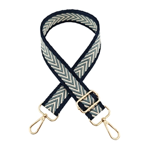 Close-up of jacquard arrow pattern strap with golden metal hooks and adjustable buckle