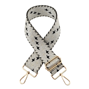 Adjustable woven crossbody bag strap with cream black geometric pattern and gold hardware