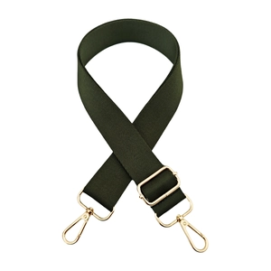 Close-up of adjustable dark green wide fabric bag strap with shiny gold metal hardware