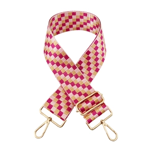 Detail of adjustable pink and gold checkered bag strap with shiny metal lobster clasps