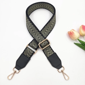 Adjustable black and gold herringbone bag strap with leather ends and metal hooks