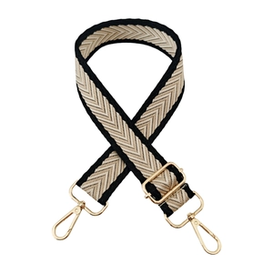 Close-up of black and white herringbone woven strap with gold metal lobster clasps