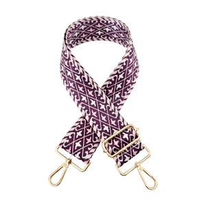 Detail of purple and white geometric jacquard nylon bag strap with gold lobster clasps