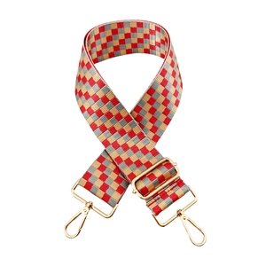 Close-up of red and gold checkered nylon bag strap with gold metal lobster clasps