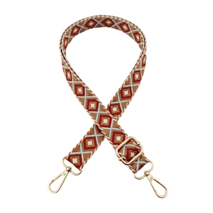 Close-up of ethnic geometric embroidery on bag strap with gold metal hardware