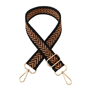 Detail of adjustable woven bag strap with golden lobster clasps and chevron pattern