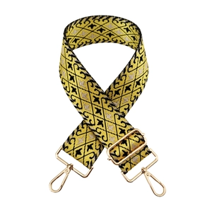 Detail of yellow geometric jacquard nylon bag strap with gold metal lobster clasps