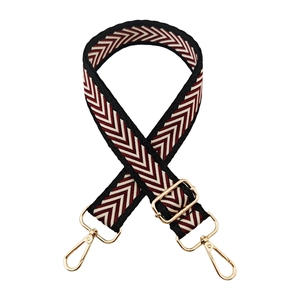 Detail of adjustable woven bag strap with red, white and black chevron arrow pattern