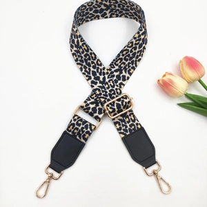 Detail of adjustable leopard print bag strap with gold metal hooks and black leather