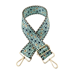 Detail of wide nylon guitar strap with vintage green floral pattern and gold metal hooks