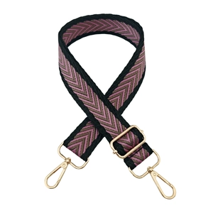 Detail of adjustable woven purse strap with arrow jacquard pattern and gold clips