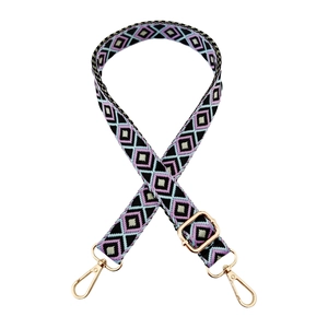Close-up of ethnic geometric diamond pattern on adjustable shoulder strap with gold hardware