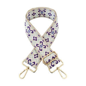 Detail of jacquard wide strap featuring purple geometric embroidery and gold carabiner hooks