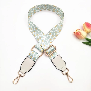 Detail of leopard print wide bag strap with gold lobster clasps and white leather ends