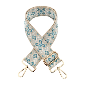 Detail of bohemian jacquard wide bag strap with blue floral pattern and gold metal hooks