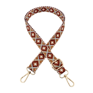 Close-up of adjustable ethnic geometric pattern strap with golden metal swivel hooks