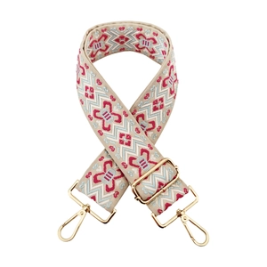 Close-up of jacquard embroidered ethnic bag strap with thick gold metal hardware