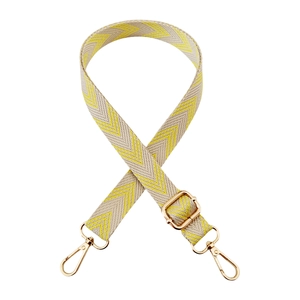 Close-up of yellow and white chevron pattern canvas strap with gold metal buckles