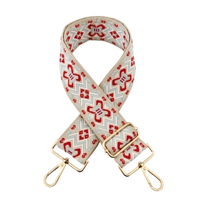 Detail of jacquard geometric pattern on thick adjustable canvas bag strap with gold hooks