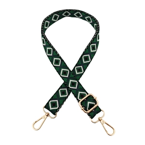 Detail of adjustable geometric diamond pattern bag strap with gold metal lobster clasps