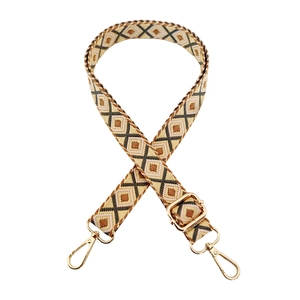 Close-up of ethnic geometric pattern strap with adjustable golden metal buckles