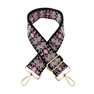 Detail of adjustable ethnic style bag strap with floral jacquard and gold metal buckles