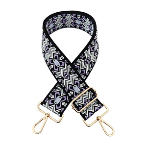 Detail of jacquard geometric embroidery on wide shoulder strap with gold metal buckle