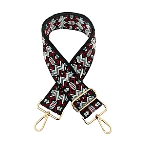 Detail of jacquard woven strap featuring geometric patterns and golden metal swivel hooks