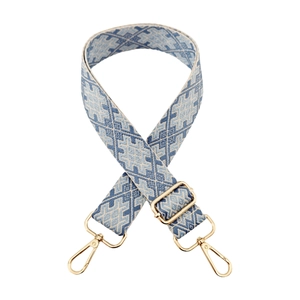 Close-up of geometric jacquard bag strap with gold metal lobster clasps and buckle