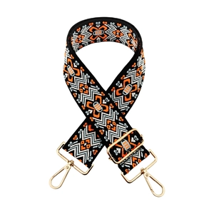 Close-up of ethnic jacquard strap with orange floral embroidery and gold metal hooks