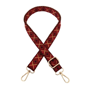 Close-up of ethnic geometric pattern strap with golden swivel hooks and metal buckle