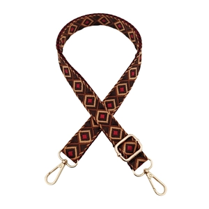 Close-up of geometric jacquard bag strap with gold lobster clasps and metal buckle